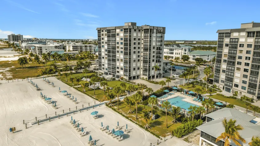 Caper Beach Club Resort in Fort Myers Beach, Florida, featuring beachfront condominiums with Gulf views, a heated pool, and direct access to the white-sand beach.