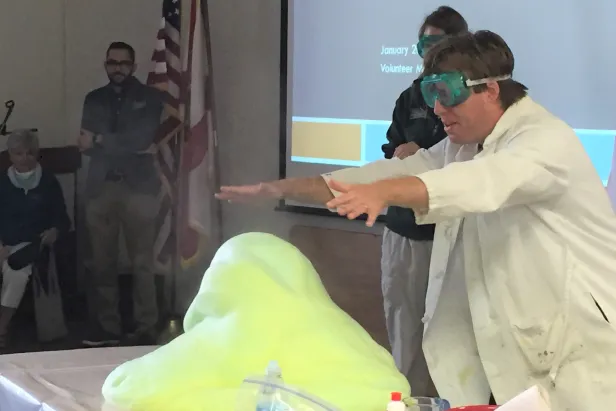 Staff performing experiment with campers
