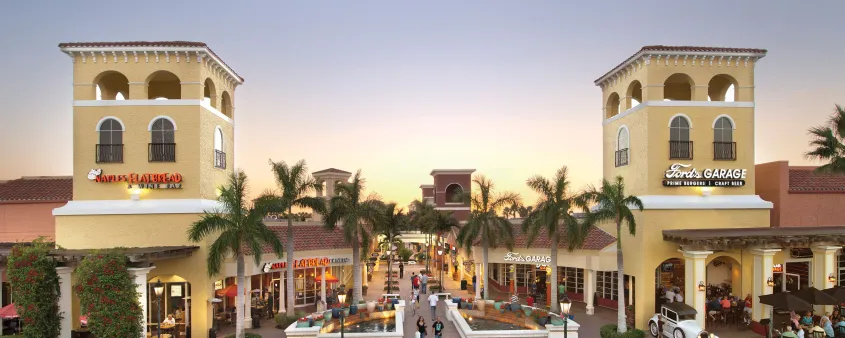 Palm-lined plaza at Miromar Outlets in Estero with Naples Flatbread and Ford's Garage.