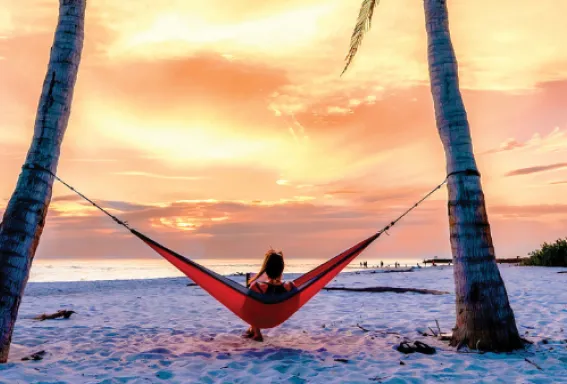 A woman relaxes as she watches a beautiful sunset